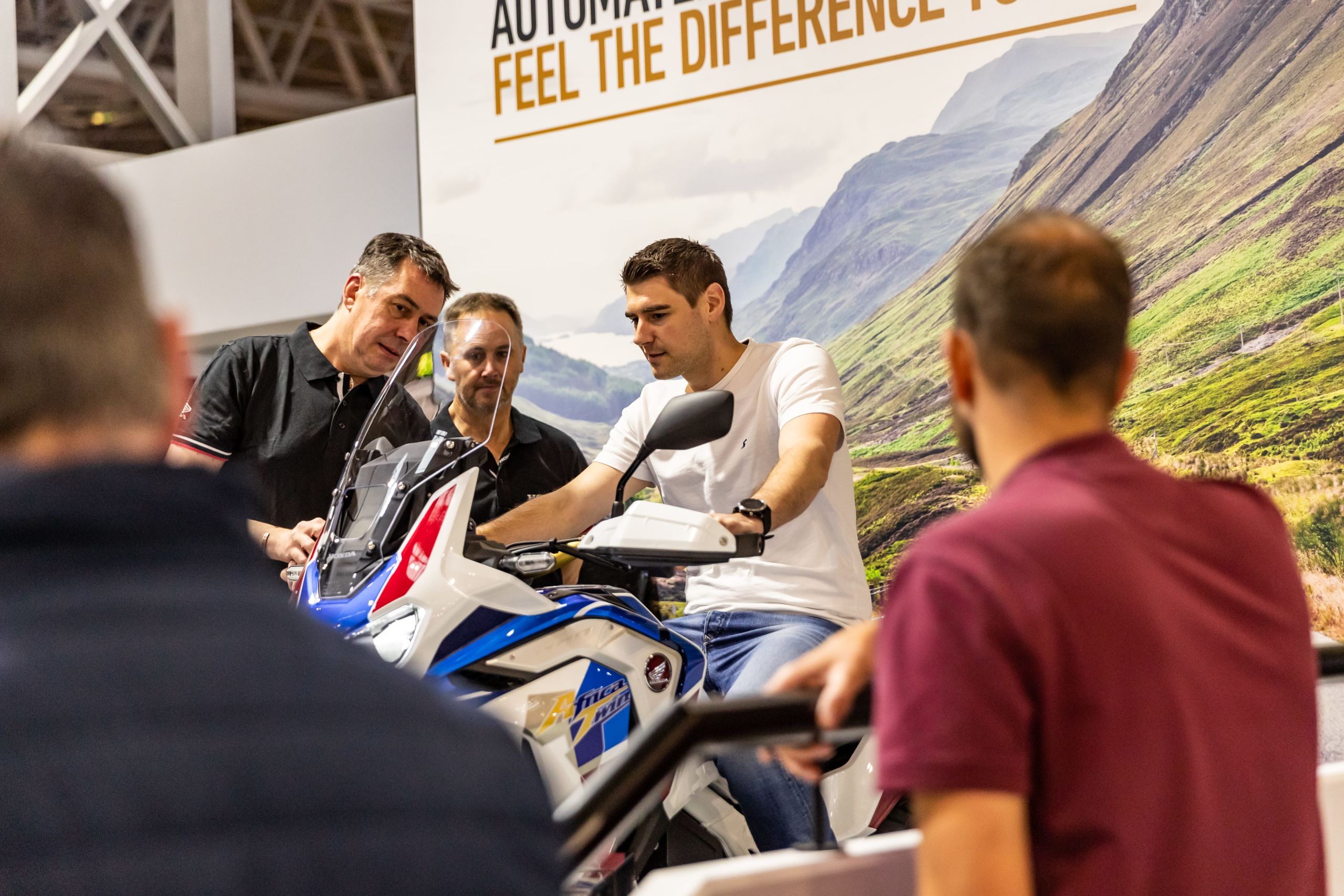 Event attendee being shown around a 2020 Honda Africa Twin Adventure Sports motorcycle by exhibitors at Motorcycle Live 2019
