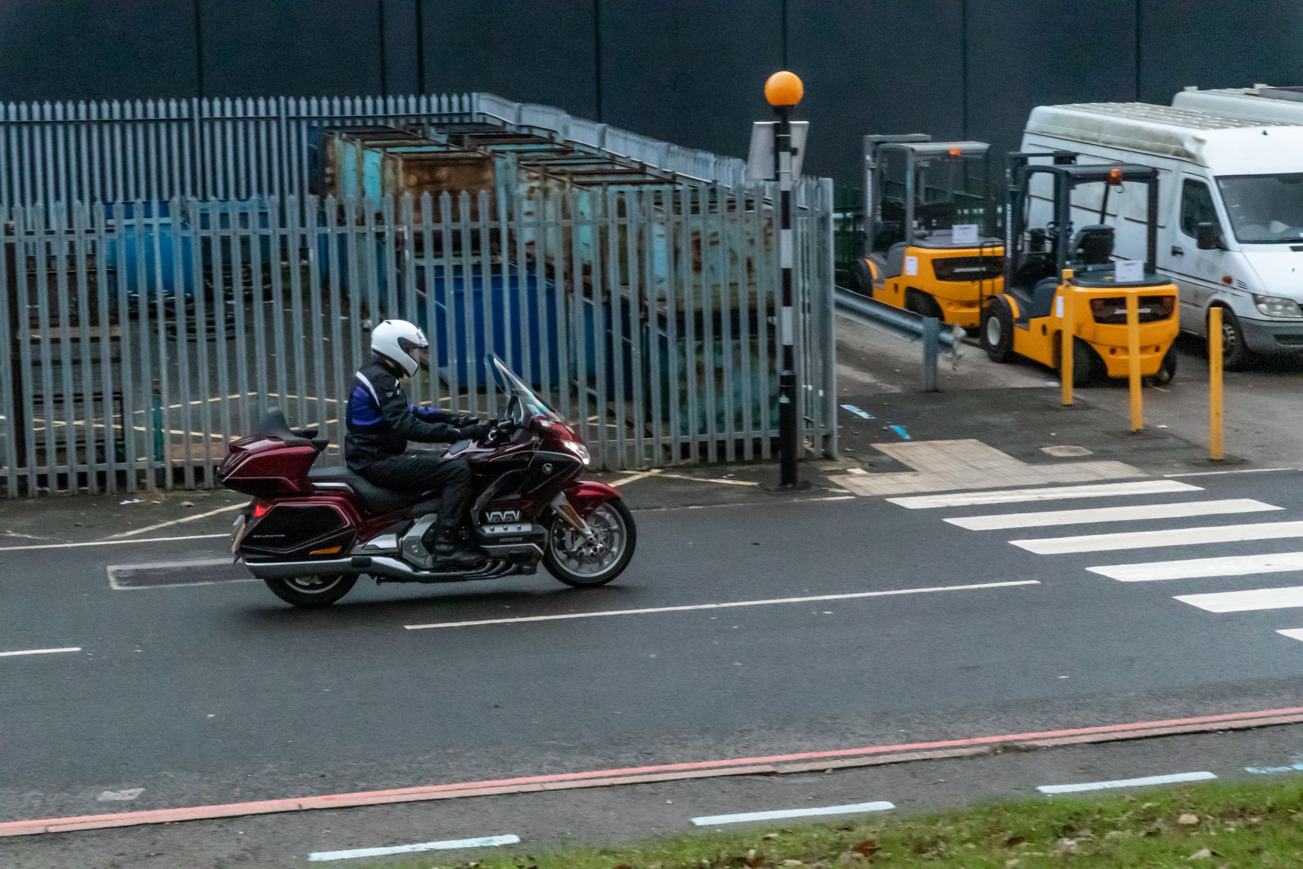 Rider riding a Honda Gold Wing on an industrial looking road