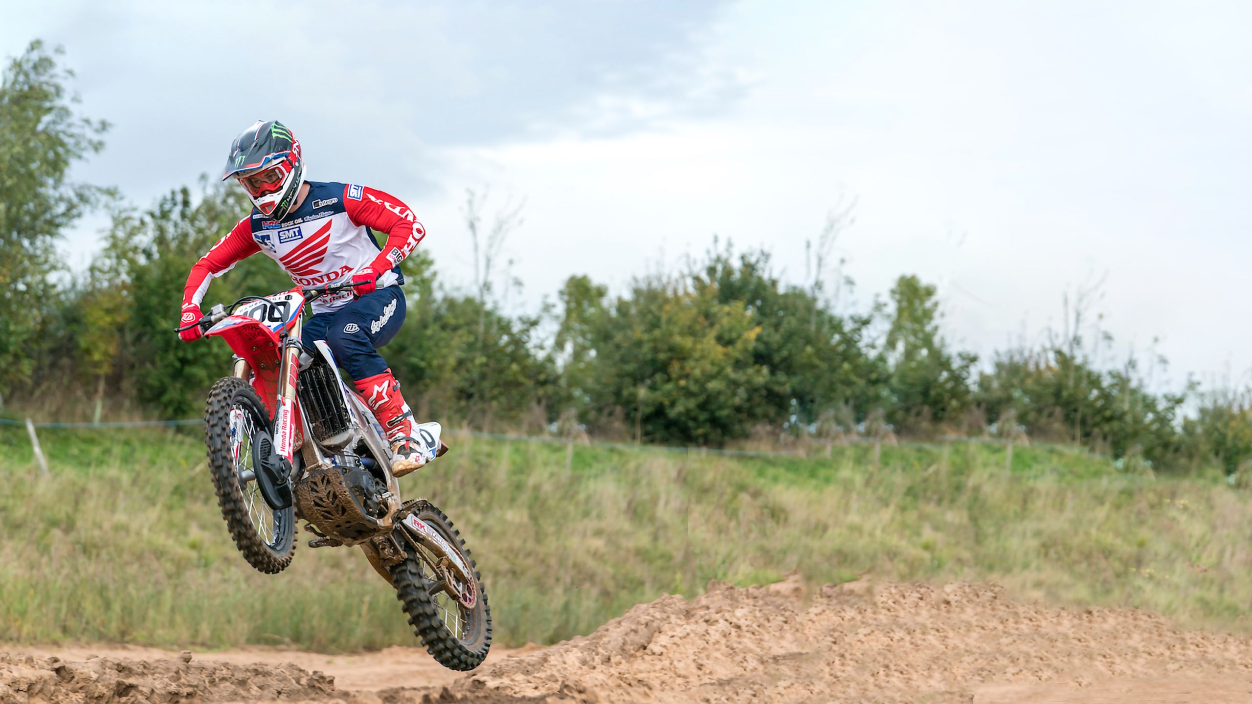 Rider mid-jump on Buildbase Honda Racing MX team bike