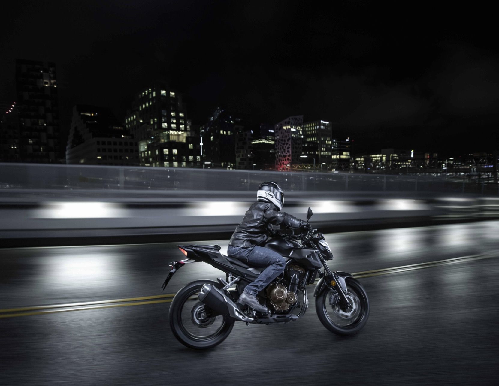Rider on black Honda motorcycle at night