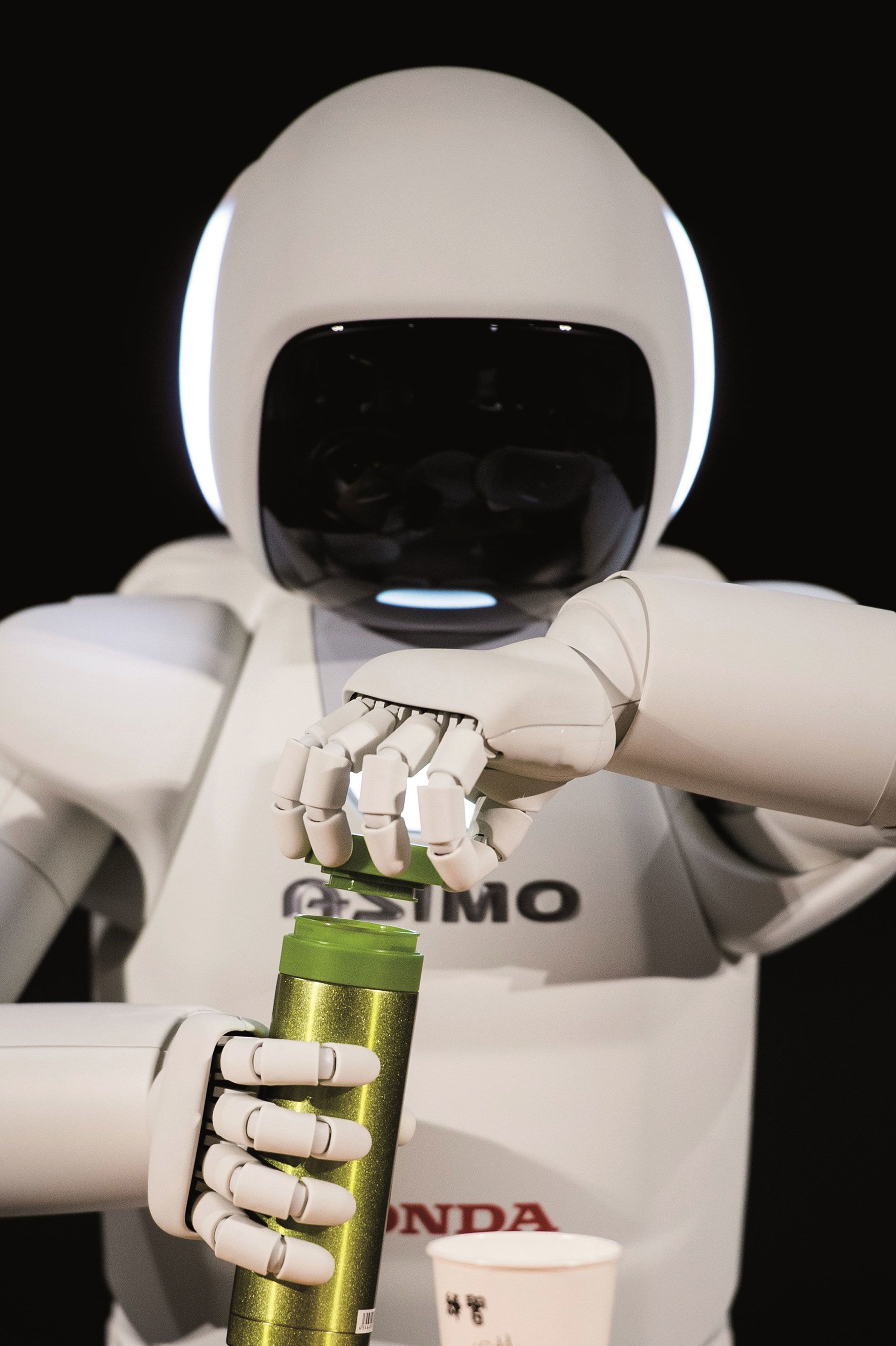 Honda ASIMO humanoid robot opening a drinks can